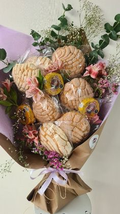 a bouquet of flowers and cookies wrapped in cellophane