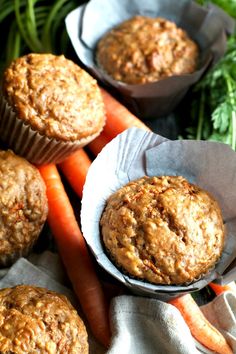 carrot muffins in paper cups on top of carrots and celery