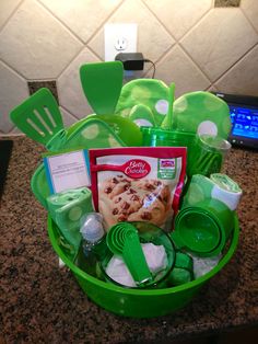 a green basket filled with lots of food on top of a counter