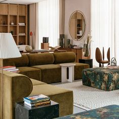 a living room filled with lots of furniture and a large mirror on the wall above it