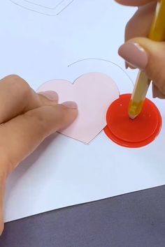 someone is cutting out hearts with a pencil