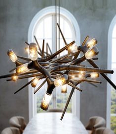 a chandelier with lights hanging from it's sides in a dining room