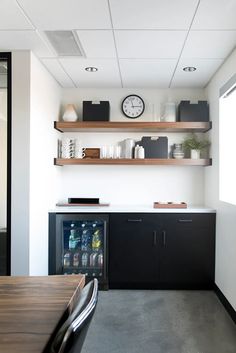 a kitchen area with shelves, cabinets and a clock on the wall