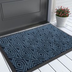 a blue door mat sitting next to a potted plant