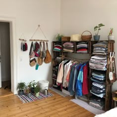 a room filled with lots of clothes and hanging racks on the wall next to a door