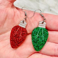 a pair of earrings with glittered christmas lights hanging from it's ear wires