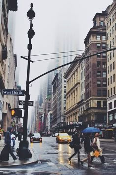 people crossing the street with umbrellas on a rainy day