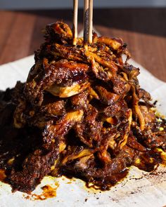 a pile of food with chopsticks sticking out of it on top of paper