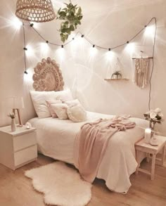 a bedroom with white walls and string lights on the headboard above the bed is decorated with plants