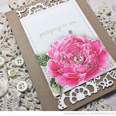 a close up of a card on a table with some buttons and lace around it