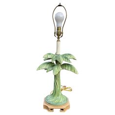 a lamp with a palm tree on it and a light bulb attached to the base