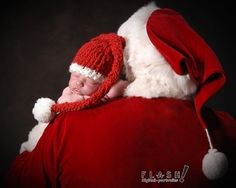 a baby wrapped up in a santa claus outfit sleeping on top of his father's chest