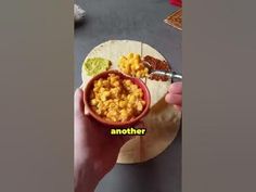 a person holding a bowl of food on top of a tortilla