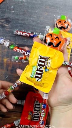 someone holding up a candy bar with halloween candies in it