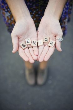 someone is holding their hands together with the word senior spelled out in scrabble letters