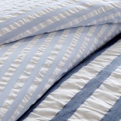 two blue and white striped sheets on top of each other