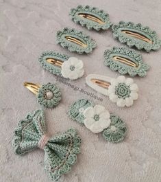 crocheted hair clips with flowers and bows are on a white surface next to other items