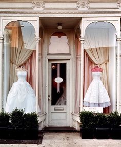 two mannequins dressed in wedding gowns are on display at a storefront