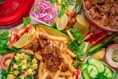 a variety of food including fries, salads and meat on a table with other foods