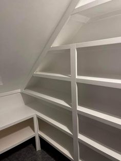 a white bookcase in the corner of a room with two shelves and one shelf