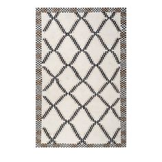 a white rug with black and brown geometric designs on the bottom, in front of a white background