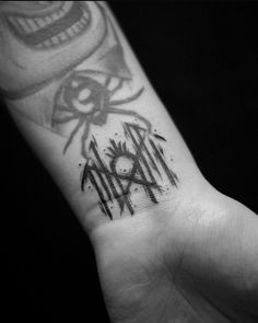 a black and white photo of a hand with a tattoo on it