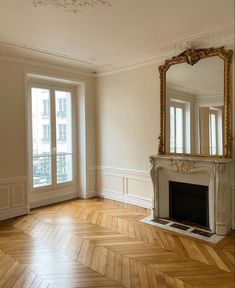 an empty room with a fireplace and mirror