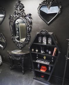 there are many mirrors and other decorative items on the wall in this room with black walls