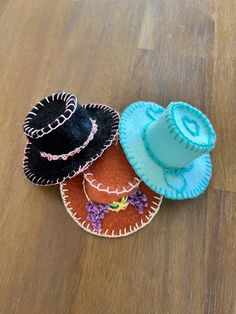 three small hats sitting on top of a wooden table