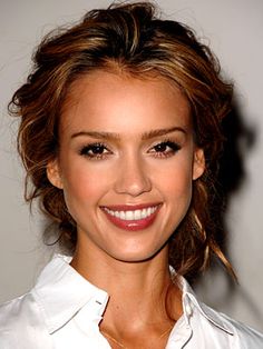 a smiling woman with brown hair and white shirt