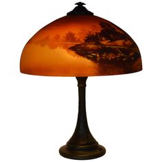 a lamp that is sitting on top of a table with a glass shade over it