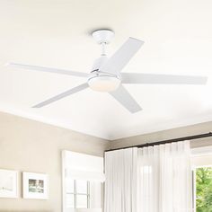 a white ceiling fan mounted above a bed