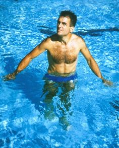 a man swimming in a pool with no shirt on