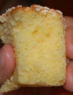 a hand holding a piece of cake in it's right hand and the other half is yellow