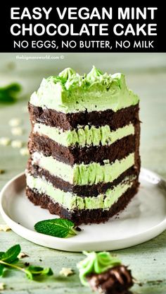 a slice of chocolate cake with green frosting on a plate next to some leaves