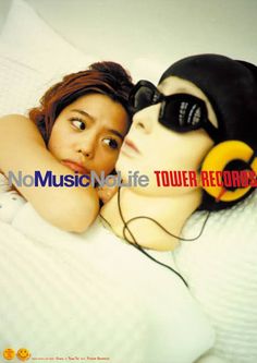 a woman laying on top of a bed next to a man with headphones on