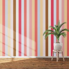 a potted plant sitting on top of a wooden stool in front of a striped wall