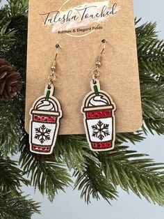 a pair of earrings hanging from a christmas tree