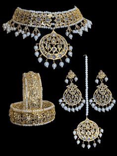 an assortment of gold jewelry on a black background