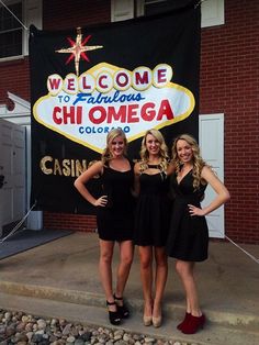 three beautiful young women standing next to each other in front of a sign that says welcome to fabulous chi omega