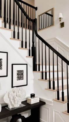 a black and white staircase with pictures on the wall next to it in a home