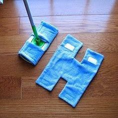 a mop is laying on the floor next to two blue towels with holes in them