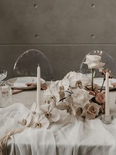 a table topped with white flowers and candles