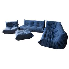 three blue couches and one chair are sitting in front of the white background,