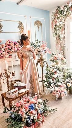 a woman standing in front of a flower filled room