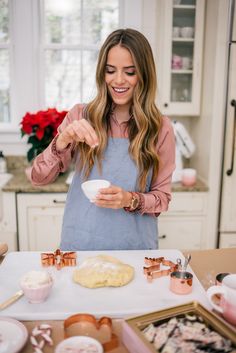 a woman in an apron is making cookies