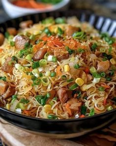 a black bowl filled with noodles and vegetables