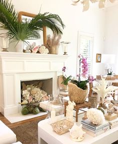 a living room filled with lots of furniture and flowers on top of a white table