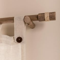 a curtain with a wooden handle hanging from it's side