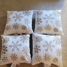 four white pillows with gold snowflakes on them